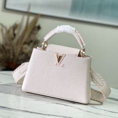 Creamy white with light pink webbing style This Capucines BB handbag focuses on exquisite craftsmanship Taurillon leather bag body and handle and shoulder strap color details reflect contrast Metal texture leather wrapped V letter Capucines series flap can be external or adduction. 

Size:27*18*9cm High-end White Satchel With Detachable Strap, High-end White Satchel With Top Carry Handle, Designer White Satchel For Everyday Luxury, Designer White Satchel For Daily Luxury, High-end Pink Top Handle Satchel, White Luxury Everyday Bags With Handles, White Luxury Everyday Bag With Handles, White Everyday Luxury Bag With Handles, White Everyday Luxury Bags With Handles