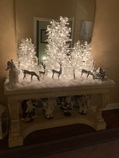 a christmas scene with white lights and reindeer figurines in front of a mirror