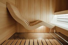 the inside of a sauna with wooden walls and flooring, including a curved staircase