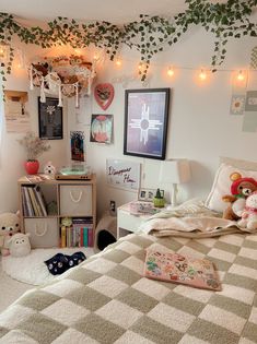 a bedroom with lots of stuffed animals on the bed and lights hanging from the ceiling