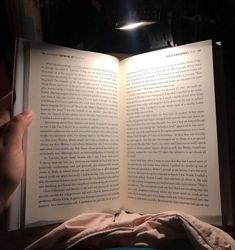 an open book is being held up in the dark