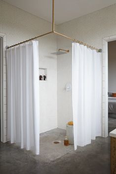 a bathroom with a shower and white curtains