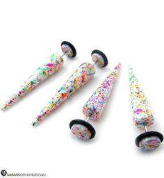 four different colored sprinkles with black tips