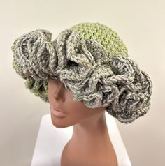 a mannequin head wearing a crocheted hat on top of a white table