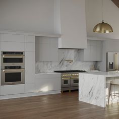 a kitchen with marble counter tops and stainless steel ovens, an island in the middle