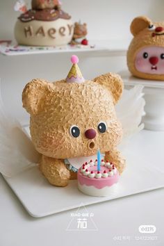 a teddy bear holding a birthday cake with candles in it's mouth and wearing a party hat