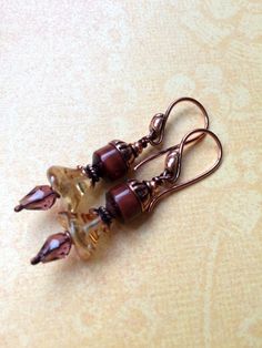 I have stacked topaz colored glass flowers, with czech drop beads, red tiger eye roundels with solid copper bead caps to create these one of a kind eclectic earrings. Dimensions: Length of the earrings: 2 inch long Brown Bead Caps For Jewelry Making, Brown Czech Glass Bead Earrings, Brown Czech Glass Beaded Drop Earrings, Brown Copper Bead Earrings, Brown Copper Beaded Earrings, Brown Copper Earrings With Round Beads, Brown Copper Jewelry With Spacer Beads, Nickel-free Brown Czech Glass Beaded Earrings, Nickel-free Brown Beaded Earrings With Czech Glass