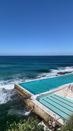 an outdoor swimming pool next to the ocean