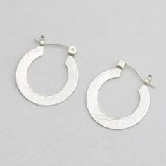 These handcrafted sterling silver hoop earrings are a must have! Feel like a diva every time you put them on! These are crafted by hand using sterling silver sheet that is cut into a "rim", then an opening is made for the earlobe. The rim is polished and pieces of hoop findings are soldered to the top. The fine silver is raised to the surface to remove firescale and to help prevent tarnishing. Then the earrings are brought to a shiny, glossy finish. One side is given a hammered texture, the othe Mother Rings, Sterling Silver Hoop Earrings, Sterling Silver Hoops, Drop Pendant, Silver Hoops, Silver Hoop Earrings, Custom Rings, Fine Silver, Precious Metals