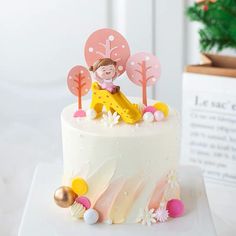 a white cake with pink and yellow decorations