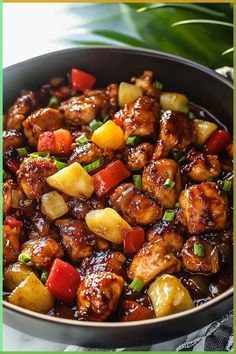 chicken and pineapple stir fry in a skillet on a table with a green border