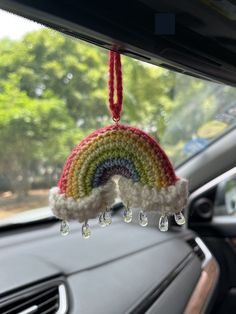 a rainbow decoration hanging from the dash of a car