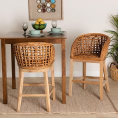 two wicker chairs sit at a small table with plates and bowls on it, in front of a potted plant