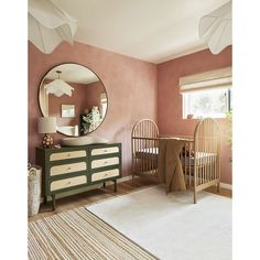 a baby's room with two cribs and a mirror on the wall