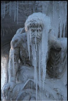 an ice covered statue with icicles hanging from it's sides