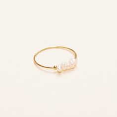 A dainty and minimal ring that is made to stand the test of time. This is a newer member of our pearl collection. With the freshwater rice pearls, this piece is for today, tomorrow, and always. - Materials: 18K gold plated titanium and freshwater pearls - Measurements: pearls are approximately 2mm in diameter - Sizes: US3- US9 - Note: the shape of the pearls may be a bit different from each other as they all grew naturally - The product is tarnish-resistant and hypoallergenic Minimalist Adjustable Rings With Pearl Drop, Minimalist Adjustable Ring With Pearl Drop, Minimalist Adjustable Pearl Drop Rings, Minimalist Adjustable Pearl Rings, Minimalist Pearl Drop Rings As Gift, Minimalist Pearl Drop Ring For Gift, Adjustable Minimalist Pearl Ring, Minimalist Pearl Rings With Pearl Charm, Tiny Minimalist Pearl Ring For Gift