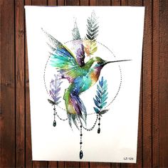 a watercolor painting of a hummingbird with feathers and beads hanging from it's wings