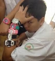 a young man is holding his head with two wrist watches on his left arm and another watch on his right hand