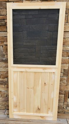 a wooden frame with a chalkboard on top of it next to some stacked wood planks