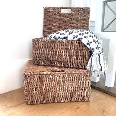 two wicker baskets stacked on top of each other in front of a door way