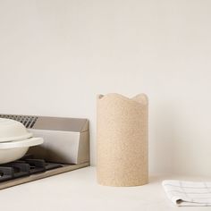 a white table with a bowl and napkins on it next to a paper towel dispenser