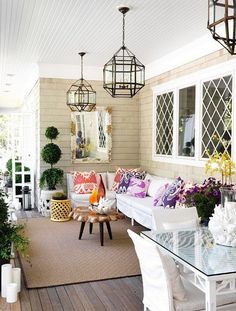 a living room filled with lots of furniture and decor on top of a wooden floor