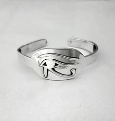 The Eye of Horus is a lasting symbol for spiritual connection, seeing with and activating the 3rd eye for visionary and intuitive guidance. This amazing hand made solid sterling silver cuff has the Eye of Horus debossed, raised, on the high polished smooth surface. It has reinforced sides for long lasting wear. This gorgeous cuff will make you feel like Egyptian royalty. This ancient symbol is humbling with the energy of the first monothiastic, one God or unification with body and spirit symbol! You will feel heads turn with this beautifully finished cuff! Symbolic Engraved Sterling Silver Cuff Bracelet, Symbolic Silver Engraved Cuff Bracelet, Spiritual Sterling Silver Bangle Cuff Bracelet, Spiritual Sterling Silver Cuff Bracelet, Adjustable Symbolic Cuff Bracelet, Adjustable Symbolic Sterling Silver Cuff Bracelet, Symbolic Sterling Silver Cuff Bracelet, Spiritual Silver Engraved Cuff Bracelet, Spiritual Sterling Silver Bracelet With Polished Finish