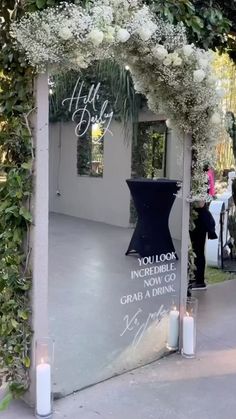 an outdoor ceremony with candles and flowers on the ground, in front of a mirror