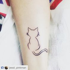 a small cat tattoo on the arm