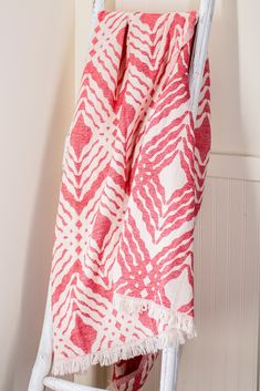 a red and white towel hanging on a ladder