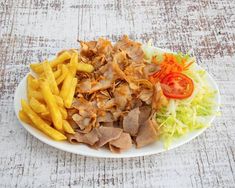 a white plate topped with french fries and meat