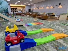 children's toys are lined up on the floor in an indoor play area with slides