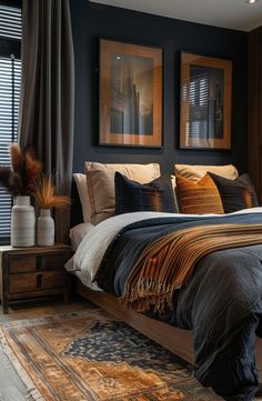 a large bed sitting next to two framed pictures on the wall in a dark colored bedroom