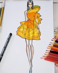 a drawing of a woman in a yellow dress on paper with crayons next to it