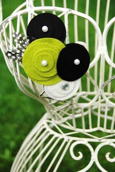 three black and green buttons are on a white wire rack with grass in the background