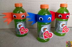 three plastic water bottles with faces on them, one is green and the other is red