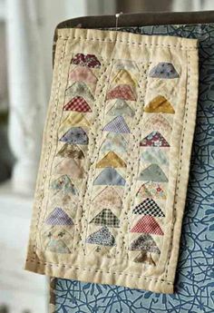 a quilt hanging on the back of a chair