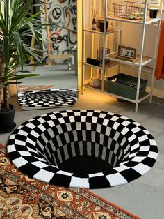 a black and white rug sitting on top of a floor next to a potted plant