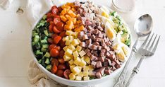 a bowl filled with chopped vegetables next to a fork