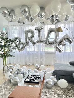 balloons are floating in the air above a living room filled with silver and white decorations