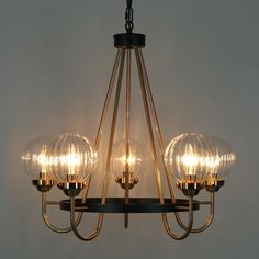 a chandelier with three lights hanging from it's sides and four bulbs on each end