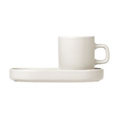 a white cup and saucer sitting on top of each other