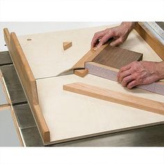 a man cutting wood with a large knife on top of a workbench that is being made