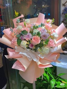 a bouquet of flowers is wrapped in pink and white paper