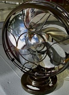 an old metal fan sitting on top of a table