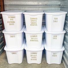 six white plastic containers with gold lettering on them in a storage area next to other bins