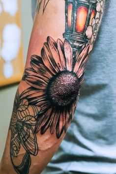 a man's arm with a flower and a lantern on it, all done by me