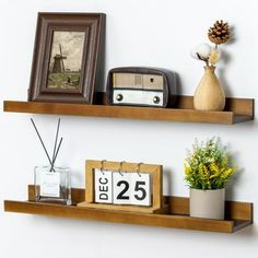 two wooden shelves with pictures and other items on them, one shelf has a clock