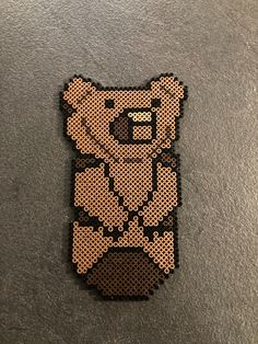 a brown bear with a bow tie on it's head is made out of perler beads