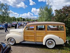 an old wooden car parked in a parking lot